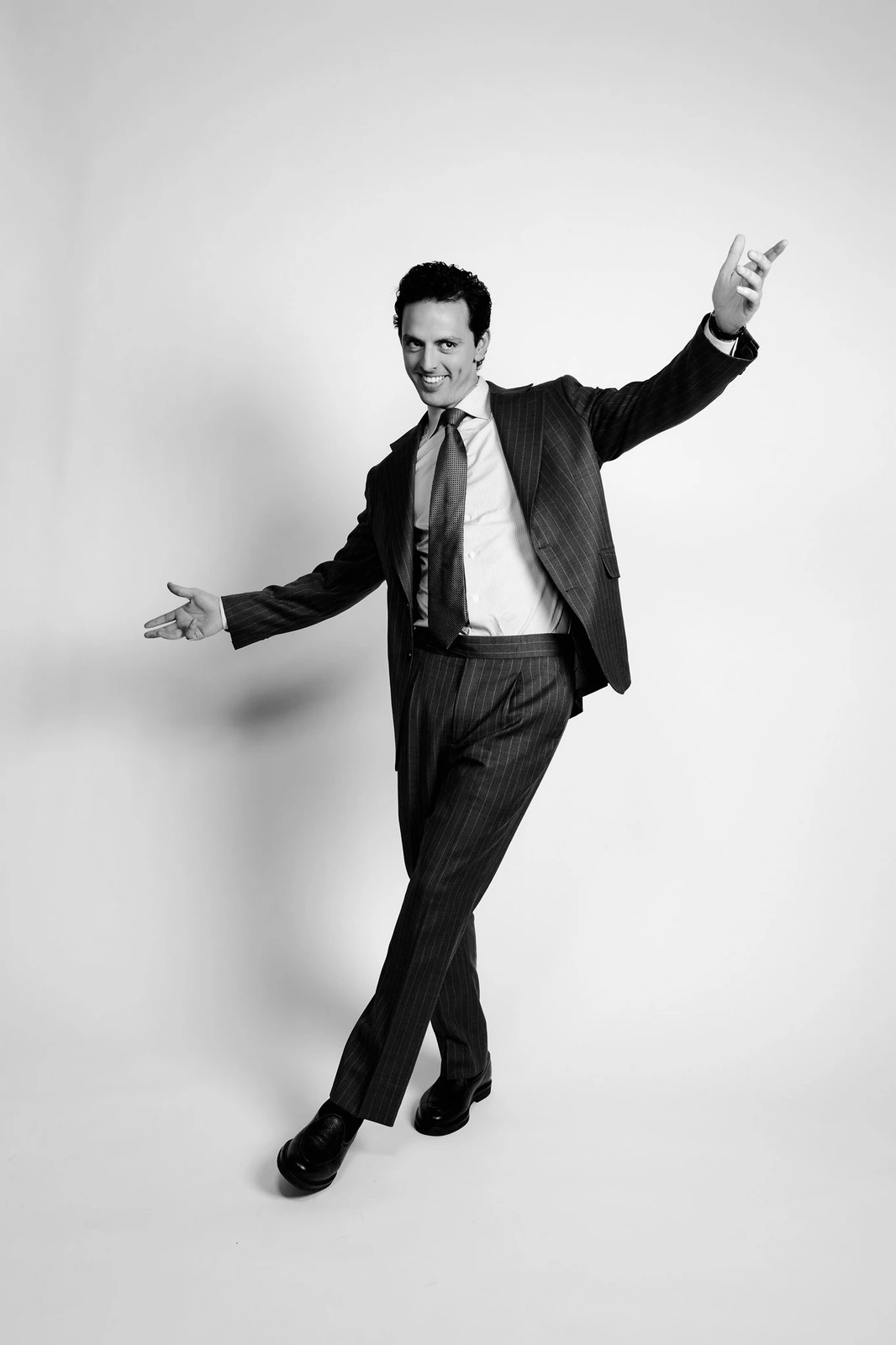 José Ramones, comediante mexicano, en pose editorial con traje y brazos abiertos para su biografía oficial