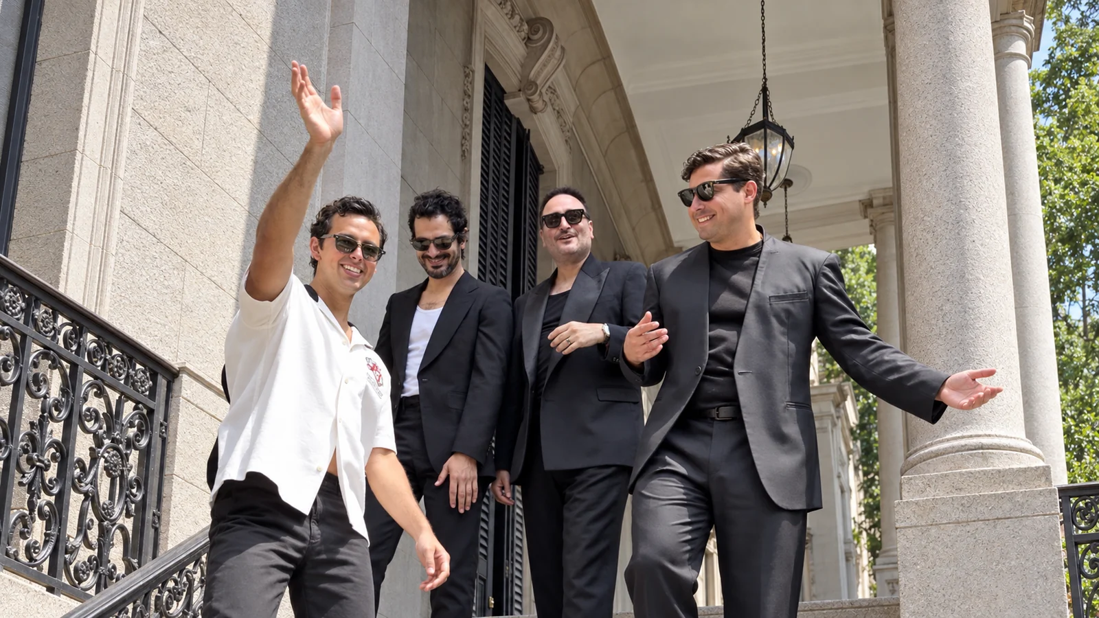 José Ramones con los integrantes de Reik en la escalinata de un edificio.