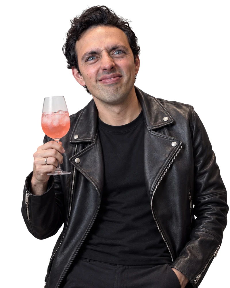 José Ramones como el amigo fresa, con chamarra negra de piel y una copa
