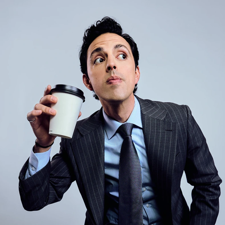 José Ramones con traje sosteniendo un café promocionando sus redes sociales oficiales