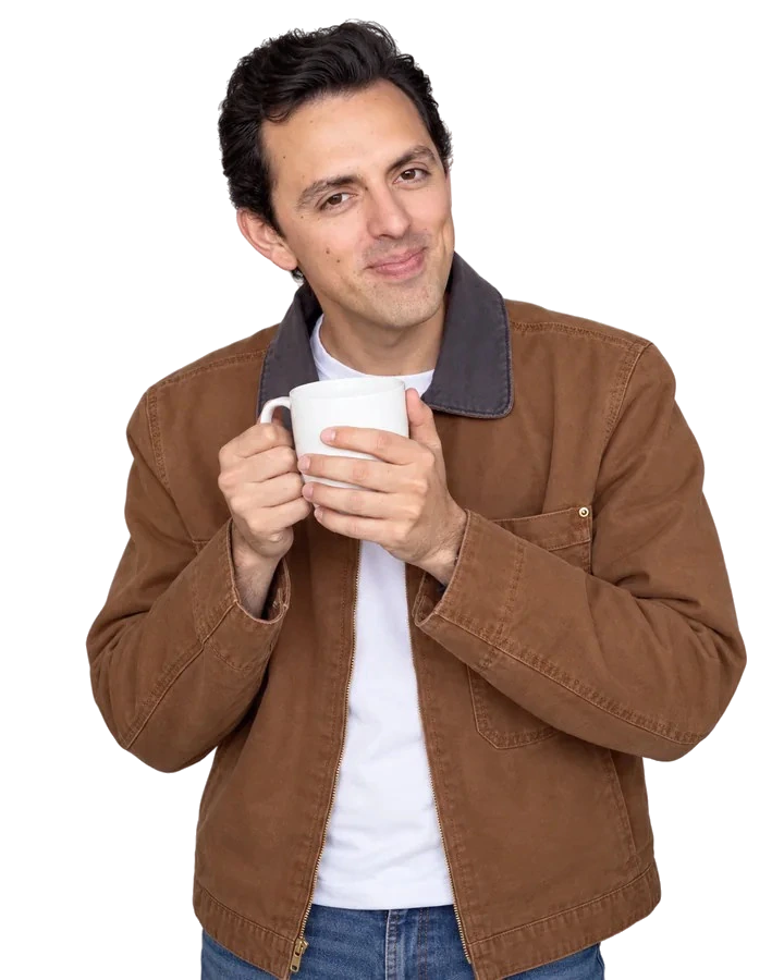 José Ramones como el amigo fan del café, con chaqueta café y una taza blanca