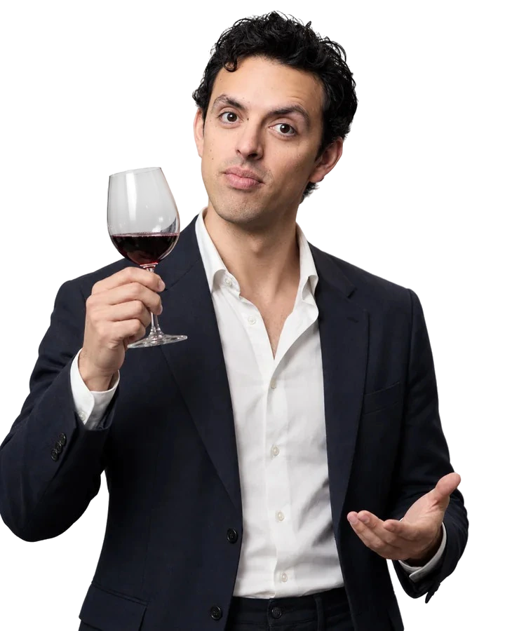 José Ramones como el amigo que sabe de vinos, con saco oscuro y una copa